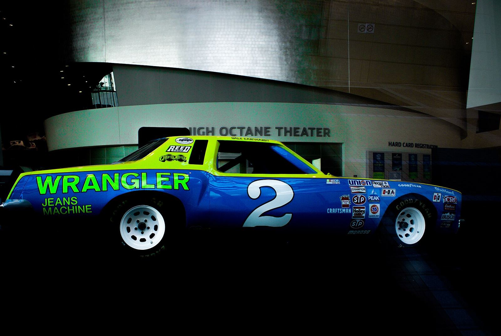 Dale Earnhardt's blue and yellow No. 2 Wrangler Jean Machine race car displayed in a darkened hall
